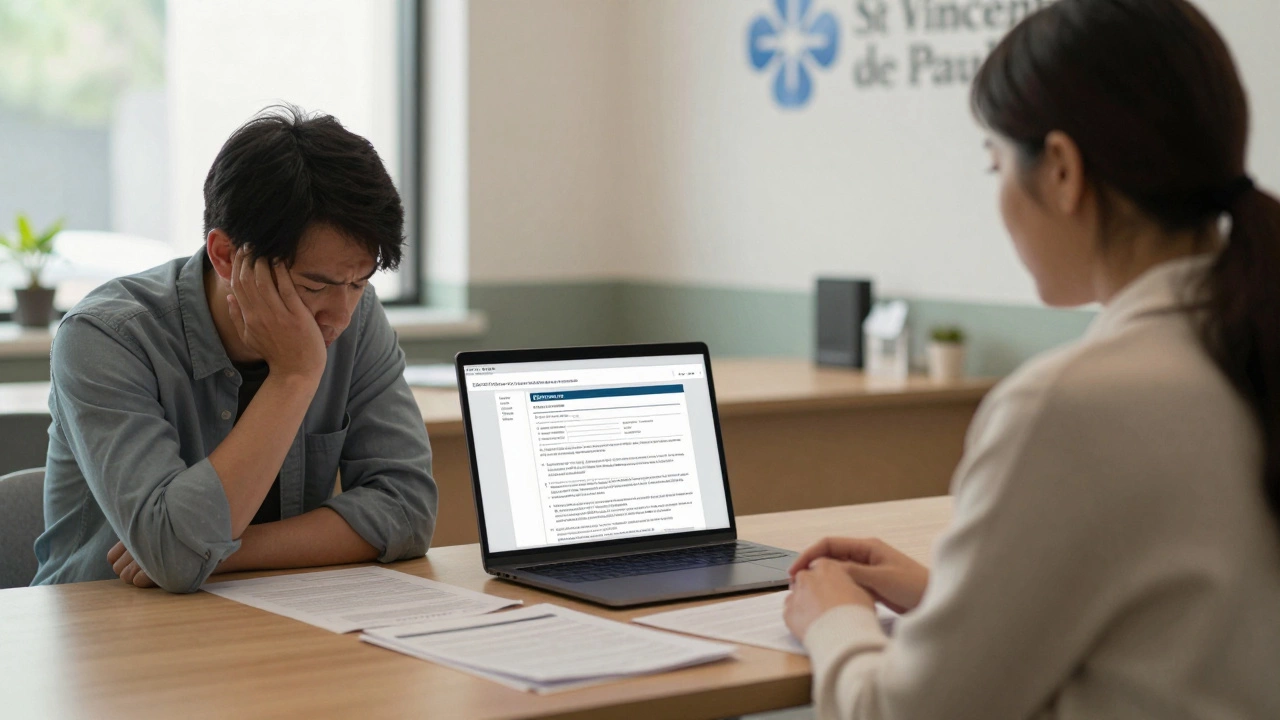 Financial counsellor helping someone with a grant application at a community center desk.